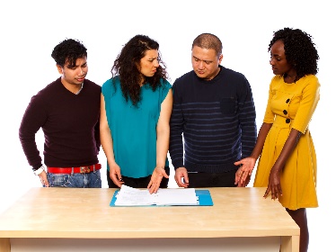 A group of people reading a document together. 