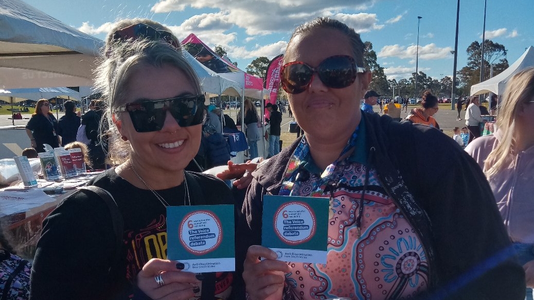 Two women looking at camera smiling holding copies of the 6 ways look after yourself and mob pocket guide