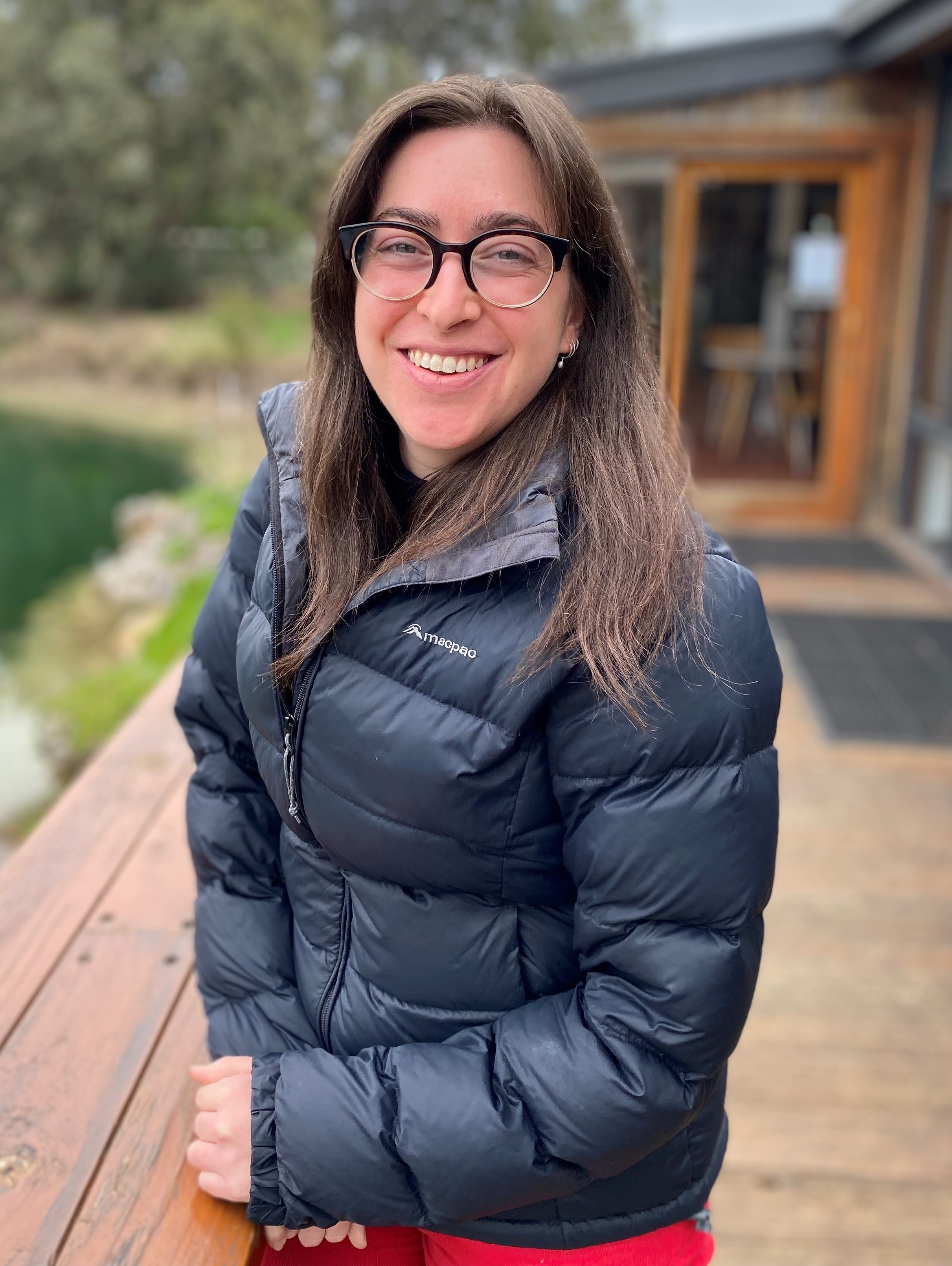 Women looking at camera smiling wearing puffer jacket and glasses